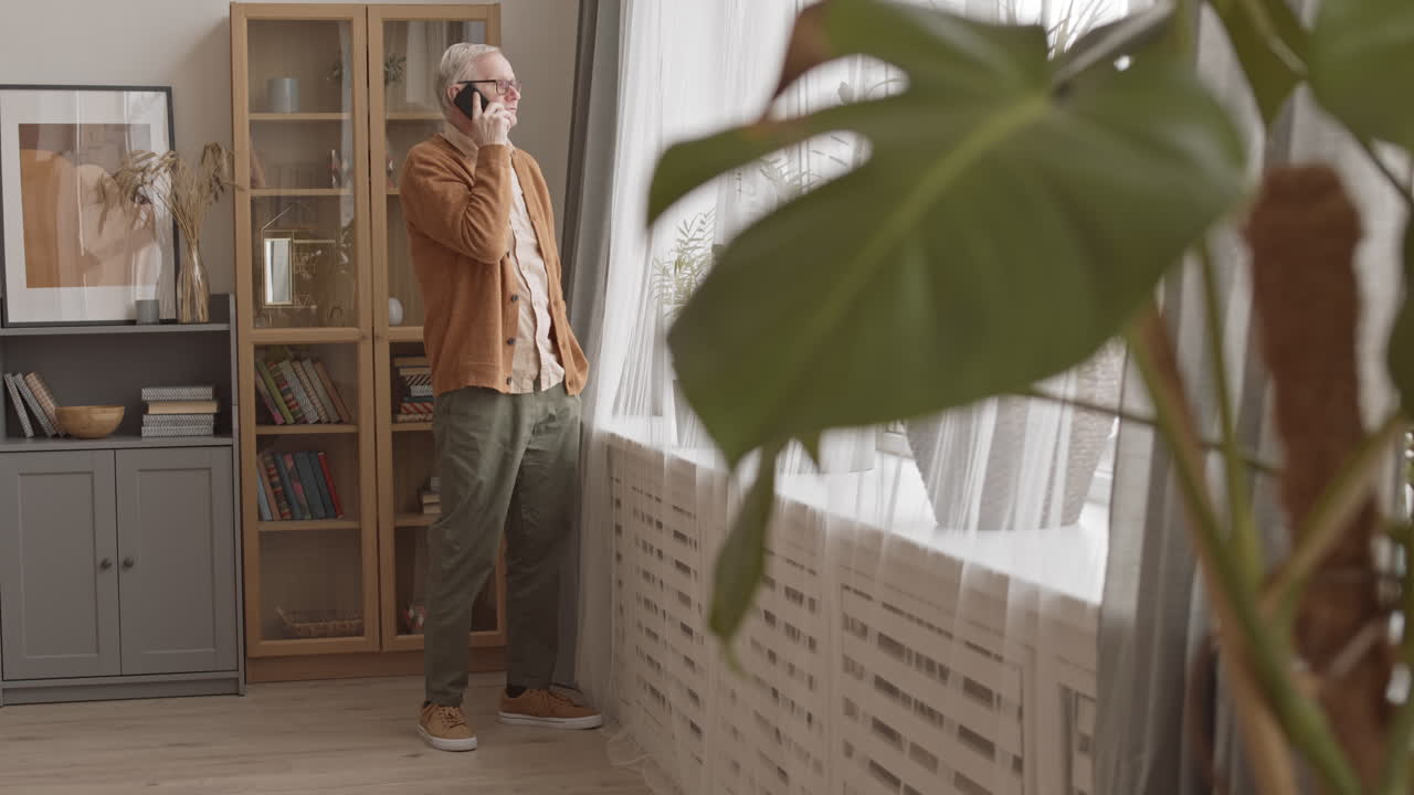 Senior Man Talking on Mobile Phone at Home