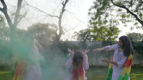 des filles indiennes jetant des couleurs de holi sur un garçon.