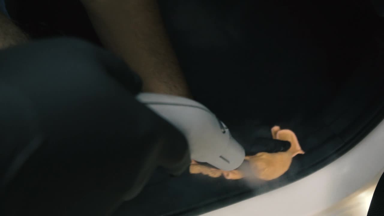 hombre con guantes negros limpiando el interior de la puerta de un auto con vapor