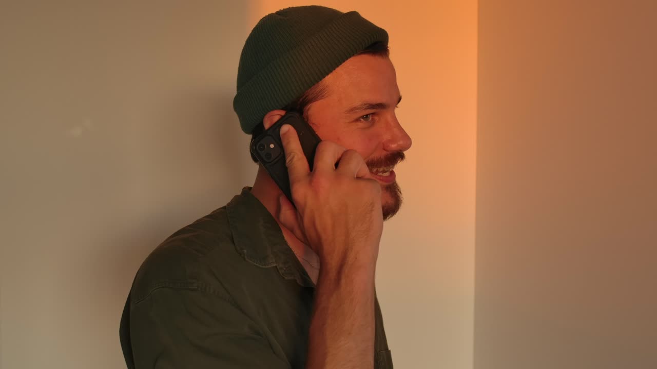 Casual Man with Beanie Calling on Smartphone - Interior Sunset Light
