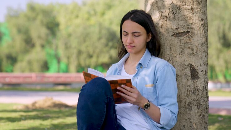 una chica india termina un libro.