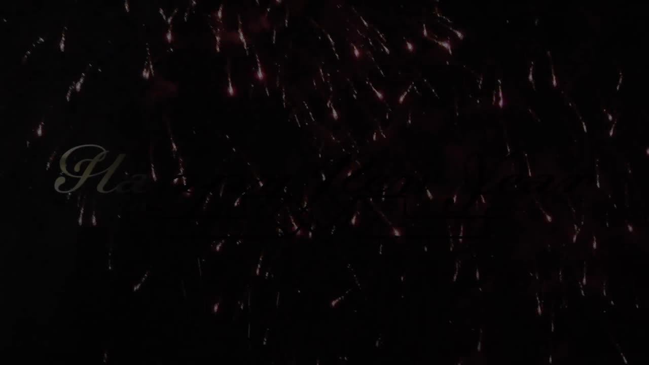 animación digital de texto de feliz año nuevo dorado contra obras de fuego explotando sobre fondo negro