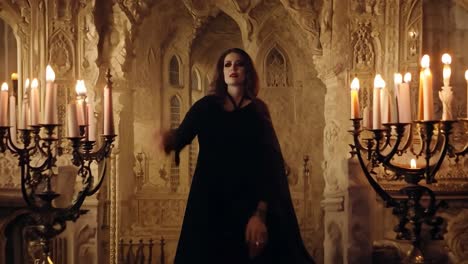 woman in black dress and red eyes standing in gothic castle with candles