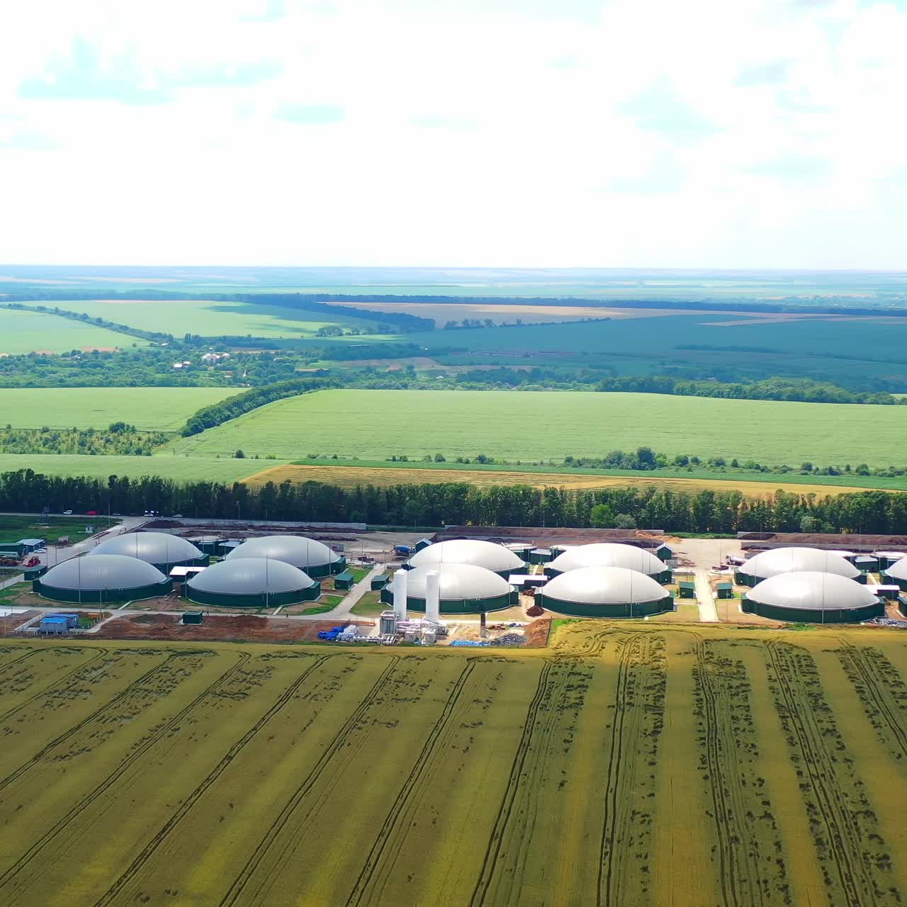 Modern farm on beautiful nature background. Agricultural reservoirs for renewable energy on field. Biotechnology concept