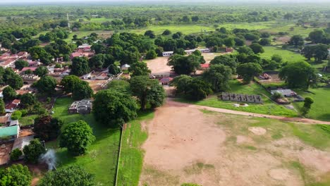 traditional village with clay houses, school and football field in gambia, africa