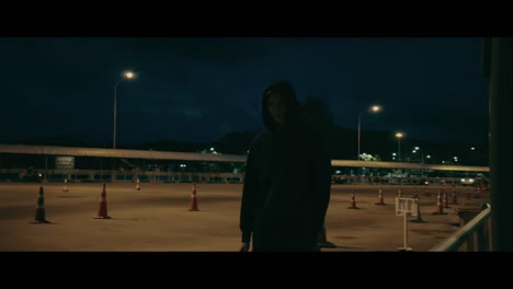 person walking at night in a parking lot