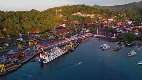 a ferry rests in padang bai port bali as drone footage captures the coastline blue water and hills surrounding this busy harbor filled with tropical charm and local boat activity.