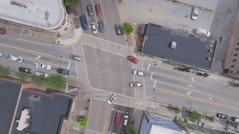 a top-down view of a busy market street intersection captures cars in motion and sharply defined lane markings framed by city sidewalks and rooftops
