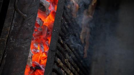 Cámara-Lenta-De-Filetes-De-Carne-Cocinados-A-La-Parrilla-Con-Leña-Al-Rojo-Vivo-En-Un-Restaurante