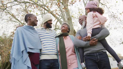 video of happy african american parents with grandparents holding granddaughter in garden