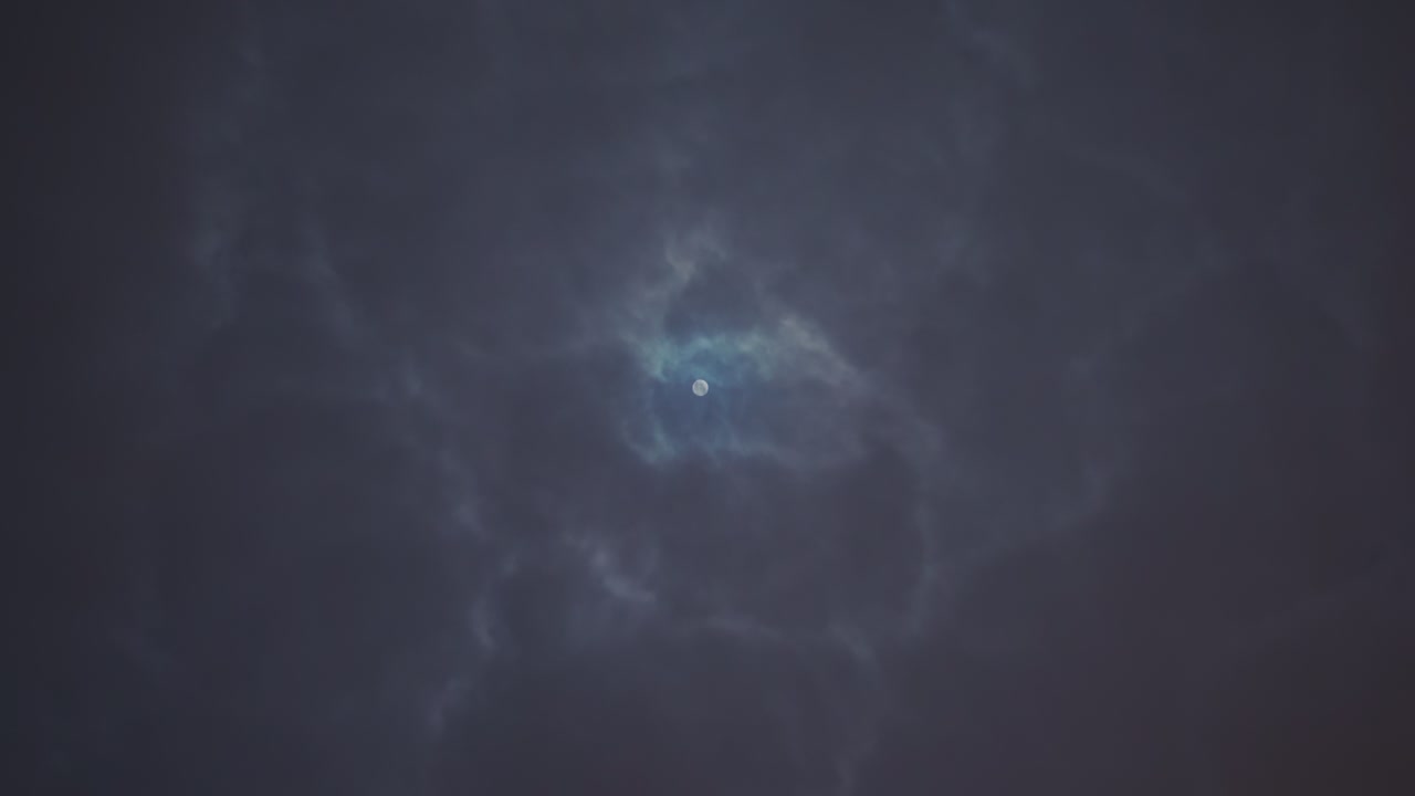 4k, la luna brilla a través de las nubes