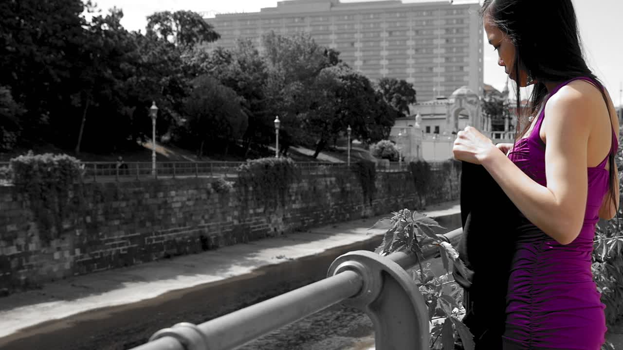 atractiva niña pequeña en vestido se pone una bufanda larga, siendo misteriosa e inalcanzable