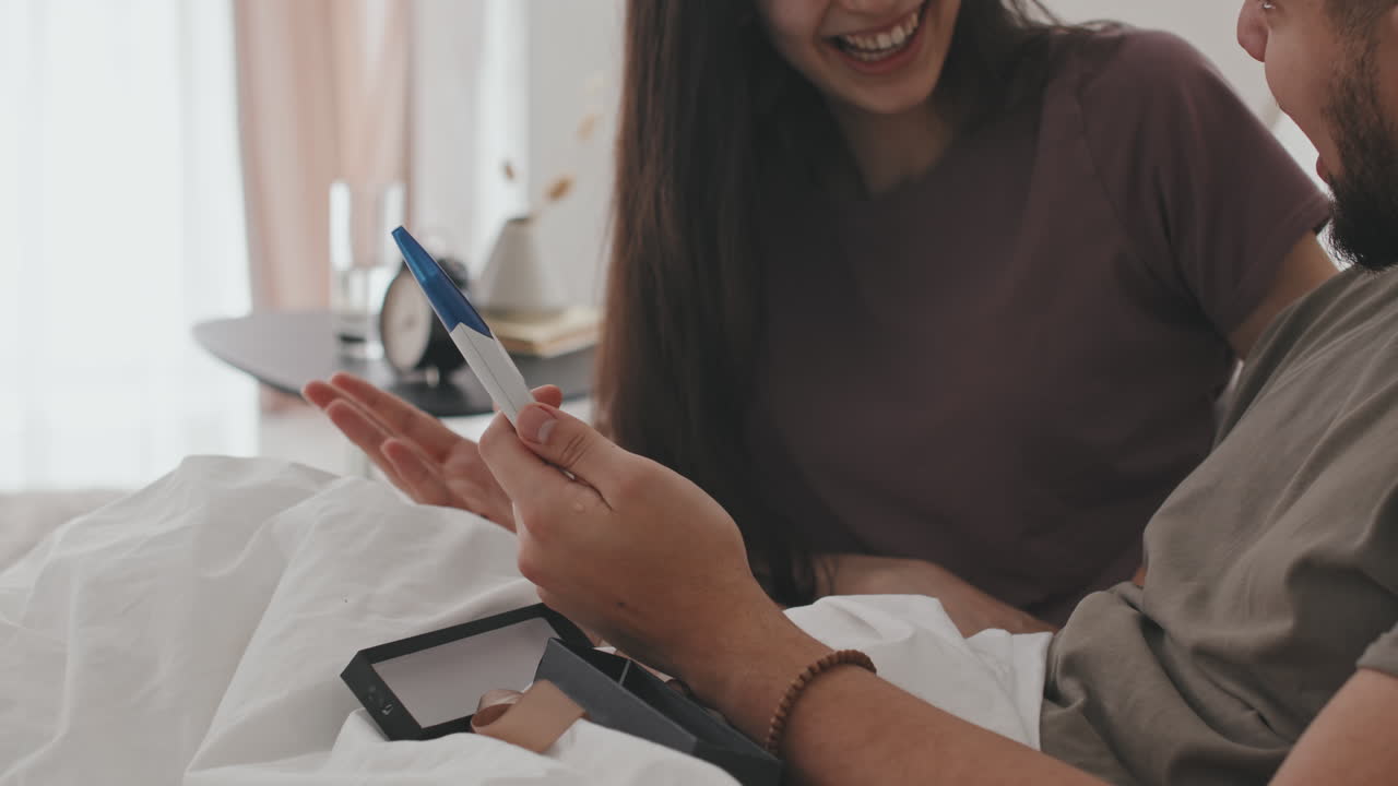 Happy Husband And Wife In Shock Holding Pregnancy Test