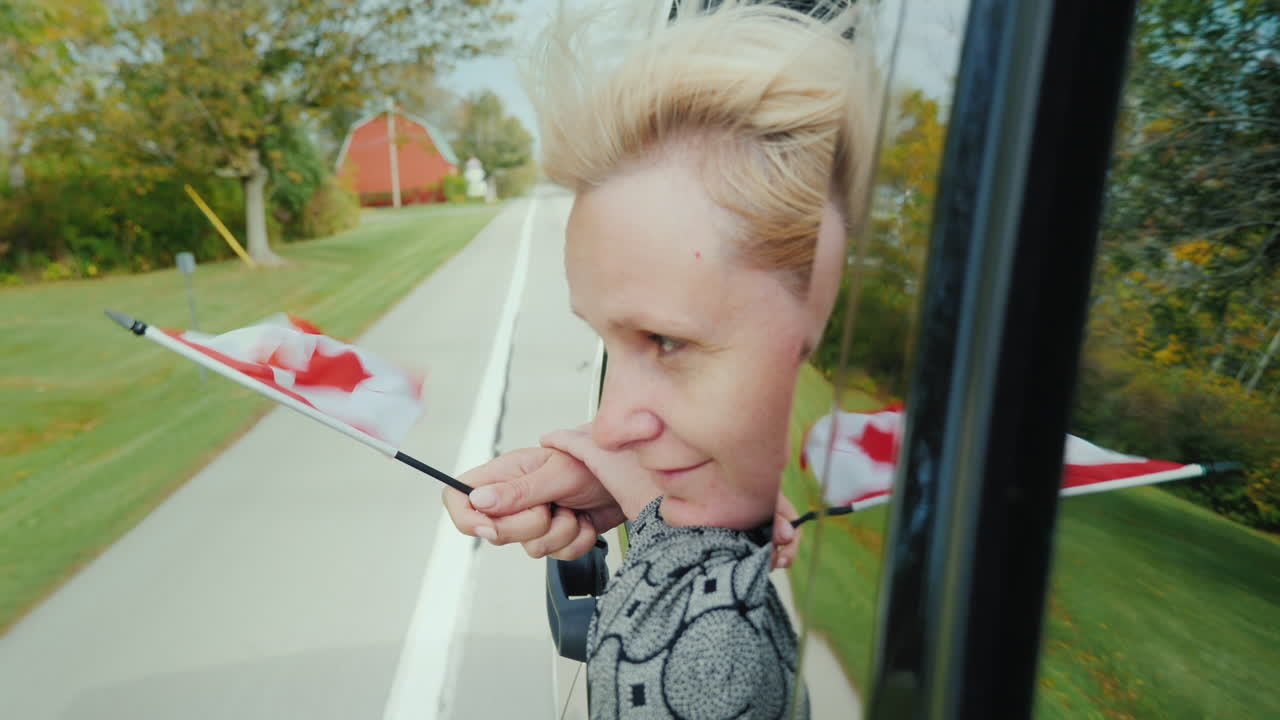 차창에 캐나다 국기를 든 여자