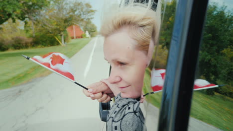 Mujer-Con-Bandera-De-Canadá-En-La-Ventanilla-Del-Coche