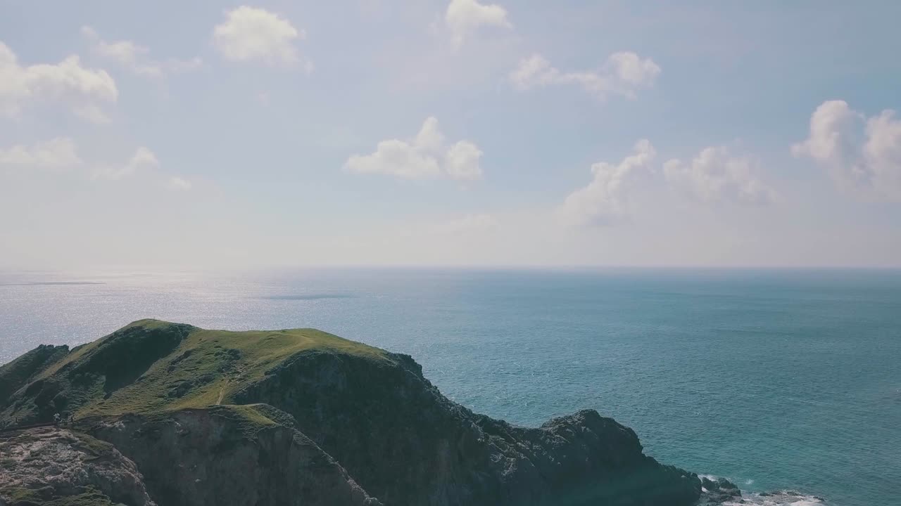 필리핀 바타네스 사브탕의 경치 좋은 산으로 파도가 튀는 영화 같은 공중 드론 비디오