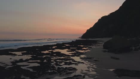 Vista-Asombrosa-Del-Cielo-Nocturno-Del-Atardecer-En-La-Playa,-La-Cámara-Se-Mueve-Sobre-La-Playa-Y-Sobre-El-Agua