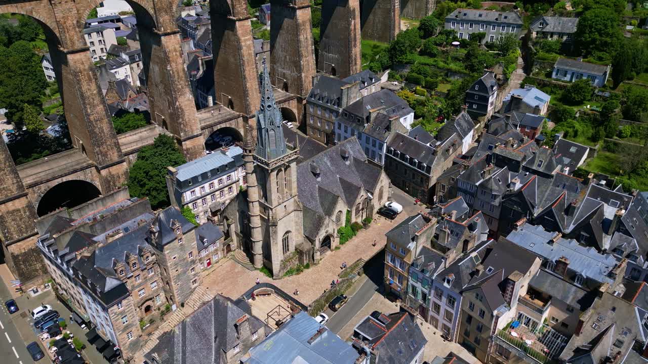 Smooth tilted panning drone movement near the gothic Saint-Melaine Church and the railway bridge like a Roman viaduct in Morlaix, Brittany, France.