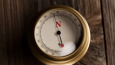 close-up of a vintage brass compass on wood