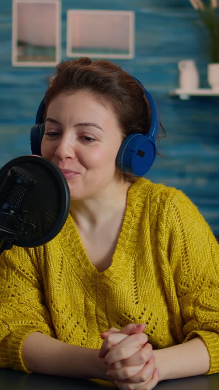 Vertical video: Woman influencer with headphones discussing with fans