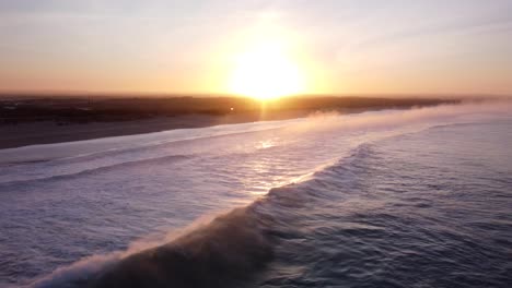 Ondas-Aéreas-Del-Océano-Que-Se-Reflejan-Con-Un-Sol-Dorado-En-El-Horizonte-Por-La-Noche