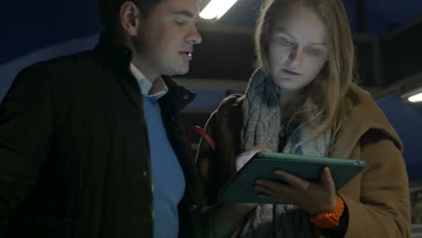 Couple-using-tablet-computer-on-flat-escalator