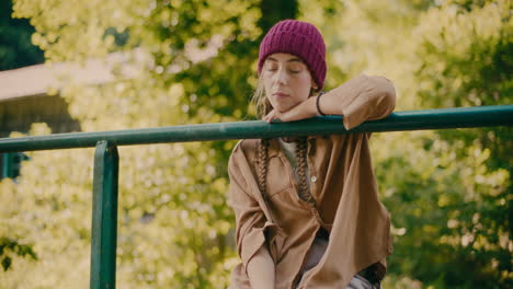 sad woman leaning on railing in forest