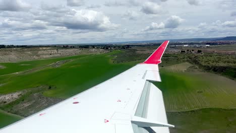 A-plane-is-landing-close-by-farmlands,-flying-over-agricultural-land