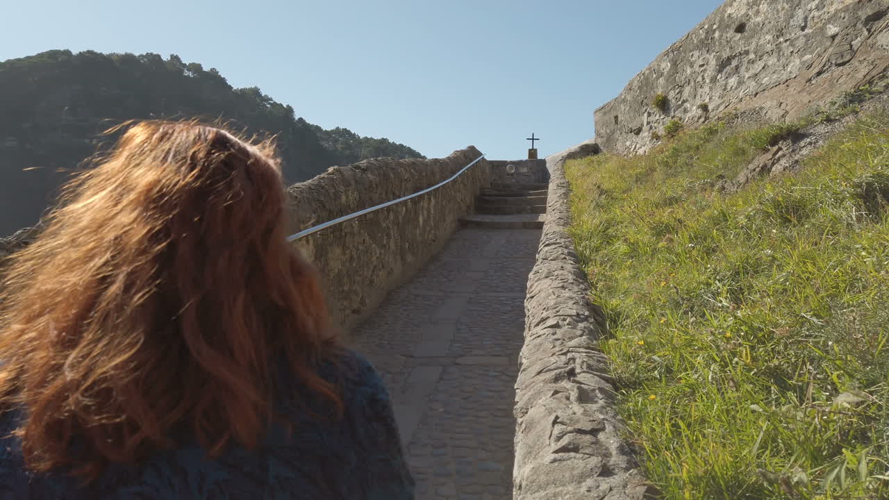 Woman walking up stairs to San Juan de Gaztelugatxe