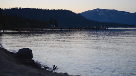 calm waves crash against pier in lake tahoe in the early morning