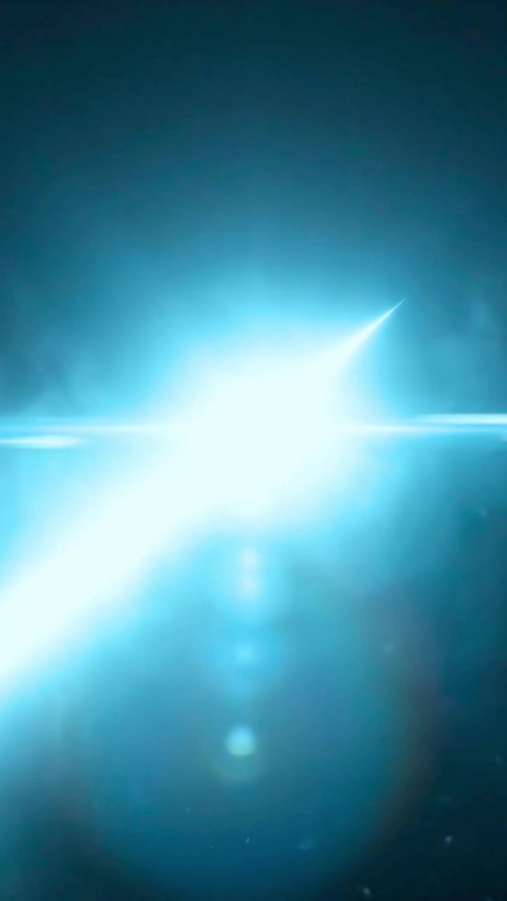 Flare blu brillante con particelle fluttuanti su sfondo scuro
