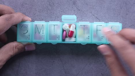 hands using a weekly pill organizer