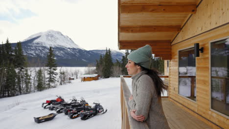 Mädchen-Auf-Dem-Balkon-Der-Lodge-Mit-Blick-Auf-Die-Haare,-Die-Zur-Winterzeit-Im-Wind-Wehen