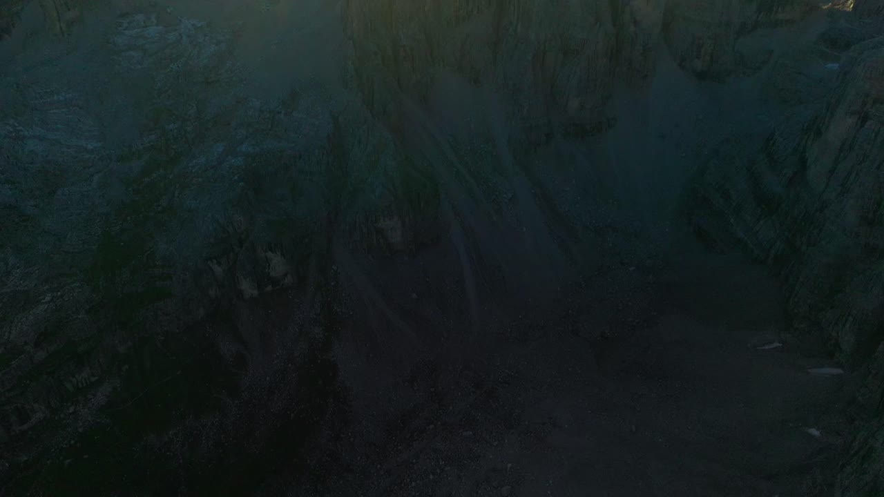 Aerial tilt up shot of rocks and mountains during golden sunset in Dolomites - Panoramic shot