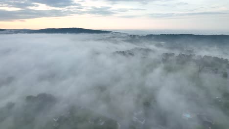 a beautiful aerial view of the fog covered landscape in the early morning light