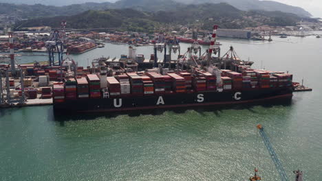 Aerial-of-fully-loaded-cargo-ship-docked-in-harbor
