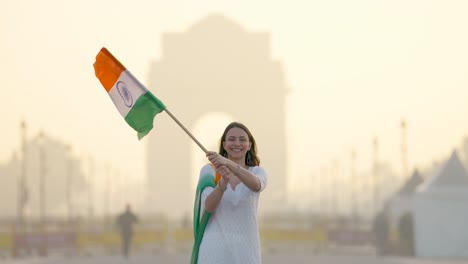 Fröhliche-Feier-Zum-Tag-Der-Indischen-Republik-Am-India-Gate-In-Delhi,-Stolze-Indische-Frau-Hisst-Indische-Flagge