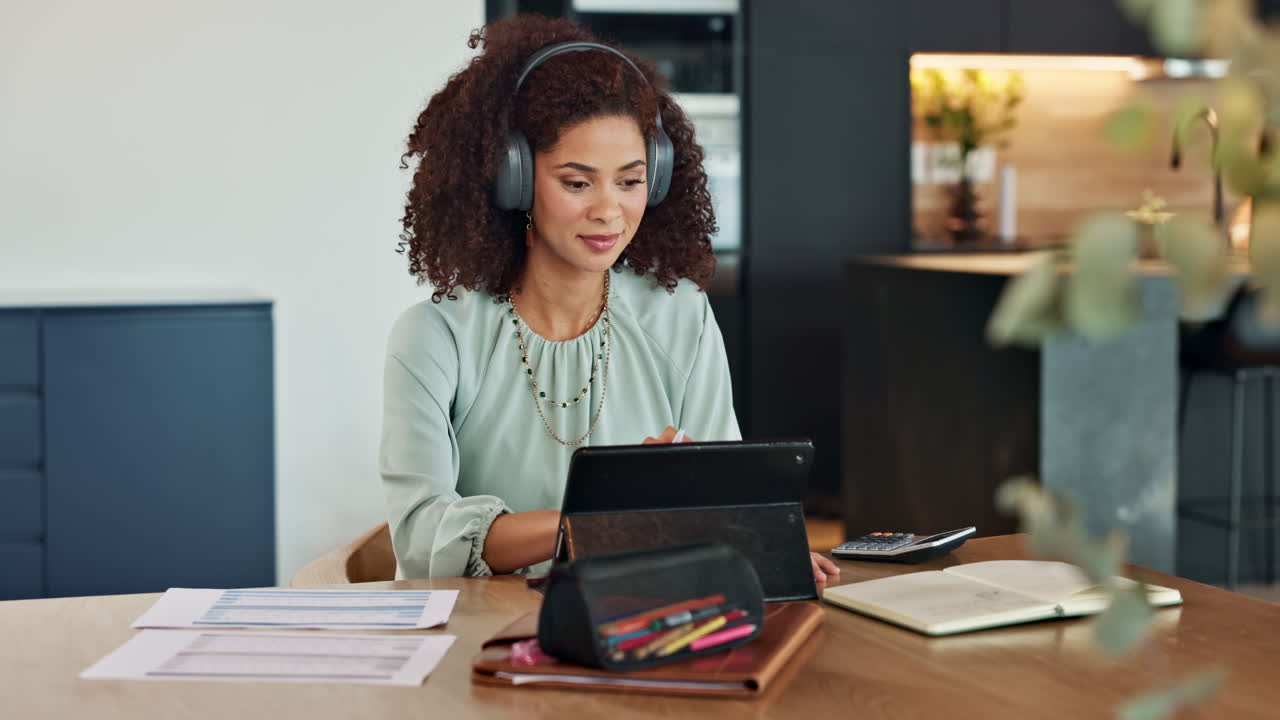 Woman working from home with tablet and headphones