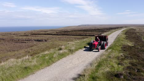 drone shot of a tractor full of peat