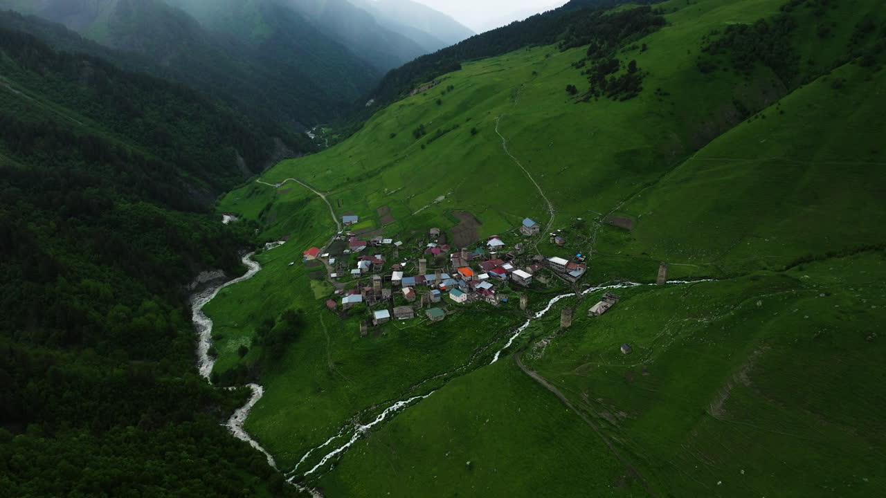 Vista aérea da aldeia de Adishi na região de Svaneti em um dia nublado na Geórgia - tomada de drone