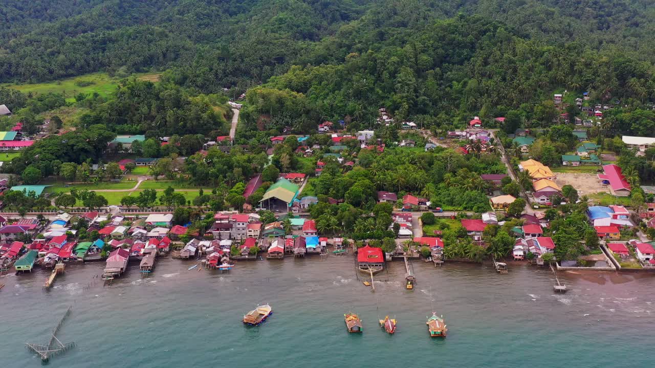 pequeña comunidad de barangay malibago con bosque verde al fondo en san bernardo, sur de leyte, filipinas