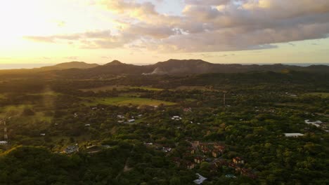 aerial pan movement above a stunning mansion towering on a mountain ridge that is covered by thick tropical rainforest