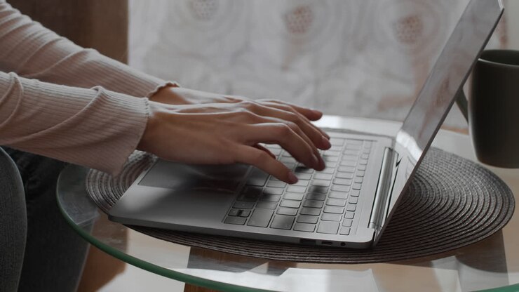 Eine Frau schreibt zu Hause auf dem Laptop