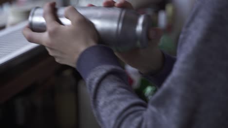 Slow-motion-of-bartender-mixing-drink-with-cocktail-shaker-inside-bar,close-up