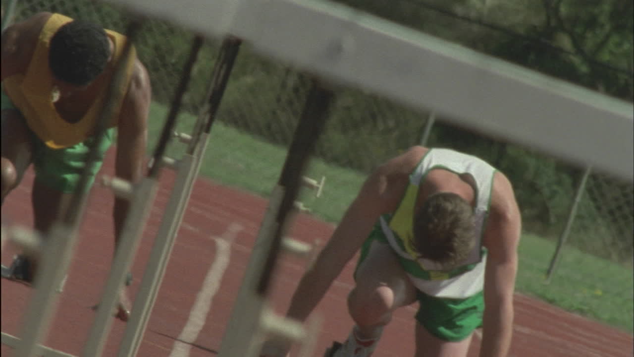 두 명의 선수가 장애물을 뛰어넘는 트랙을 질주합니다.