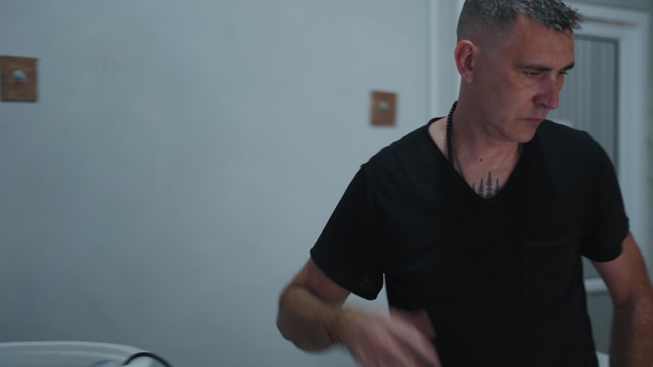 Man with tattoos working on equipment indoors