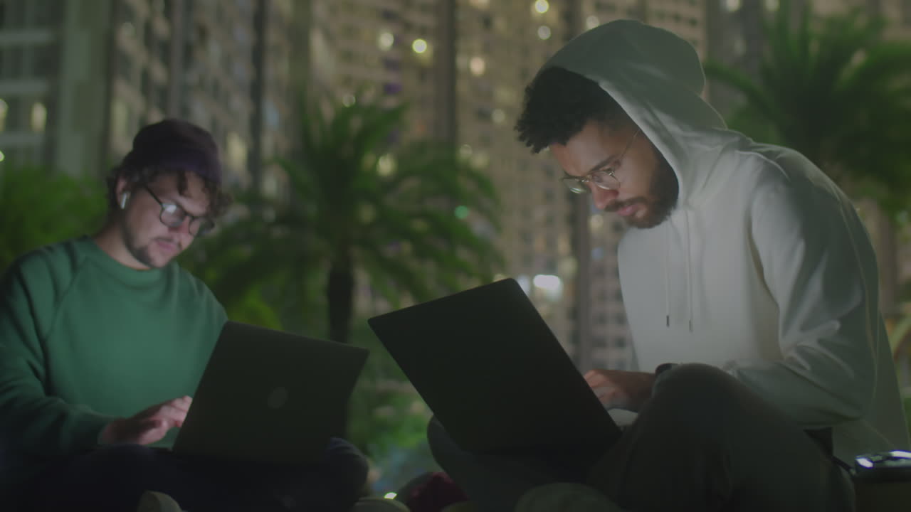 Digital Nomads Working on Laptops in Park at Night
