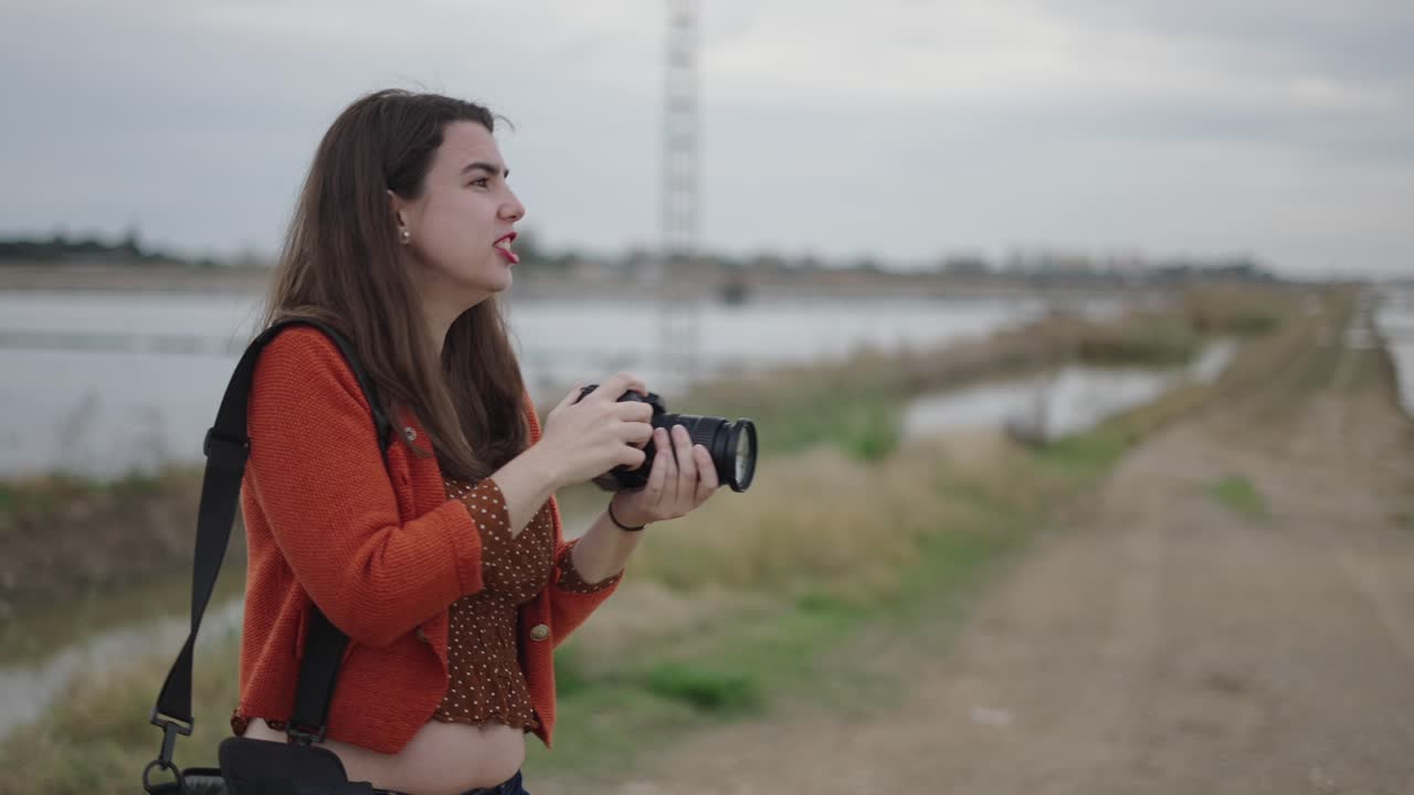 Woman taking pictures in a countryside landscape