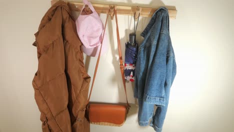 everyday items hanging on a wooden coat rack