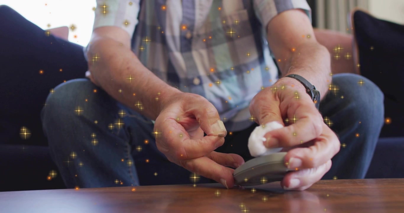 Man sitting on sofa reaching cotton ball, placing torn piece on handheld medical meter for reading